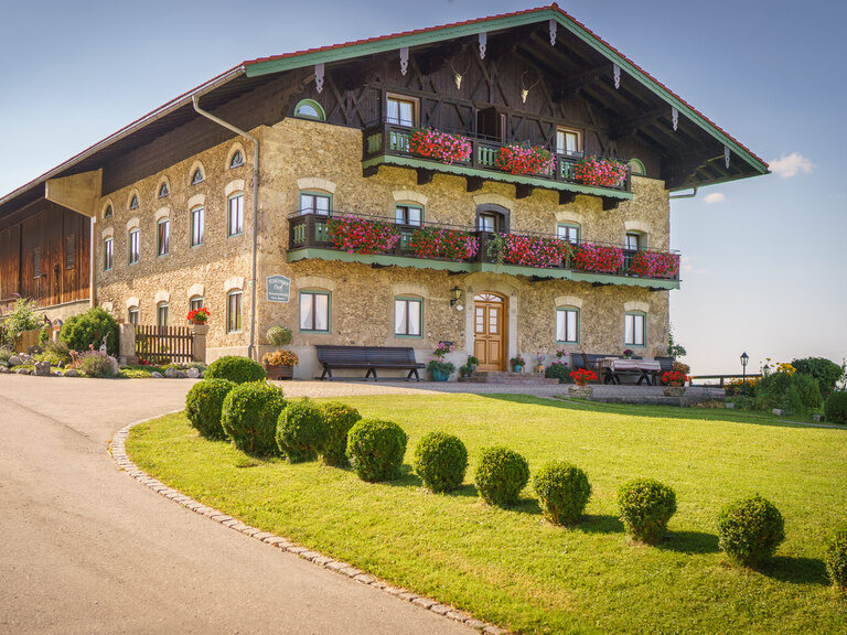 Das große Bauernhaus des Ablingerhofs mit der geteerten Einfahrt.